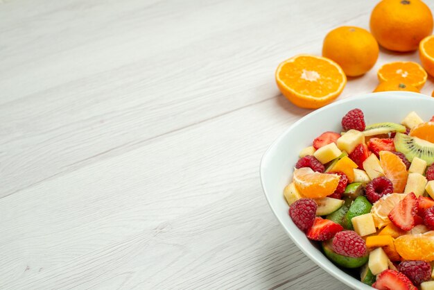 Vista de frente saborosa salada de frutas com tangerinas frescas na foto de frutas brancas maduras árvore frutada saúde madura