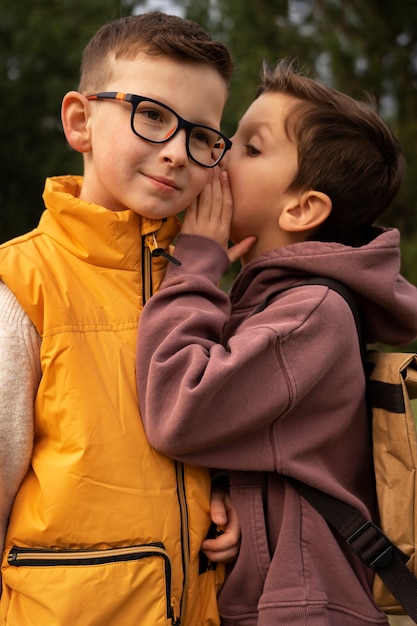 Foto grátis vista de meninos com mochilas passando tempo na natureza ao ar livre