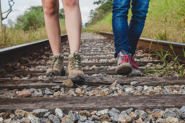 Vista de perna de casal em trilhos de trem