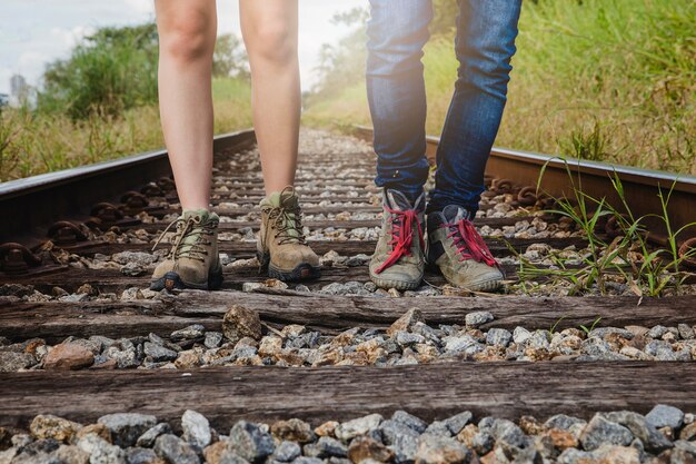 Vista de perna do casal em pé nas trilhas do trem