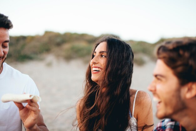 Vista de perto de amigos sorridentes na praia