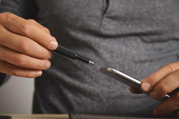 Vista de perto na micro-chave com um pequeno parafuso, desmontando o processo de telefone quebrado