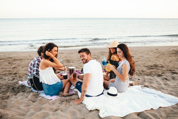 Foto grátis vista de trás de amigos com uma festa na praia