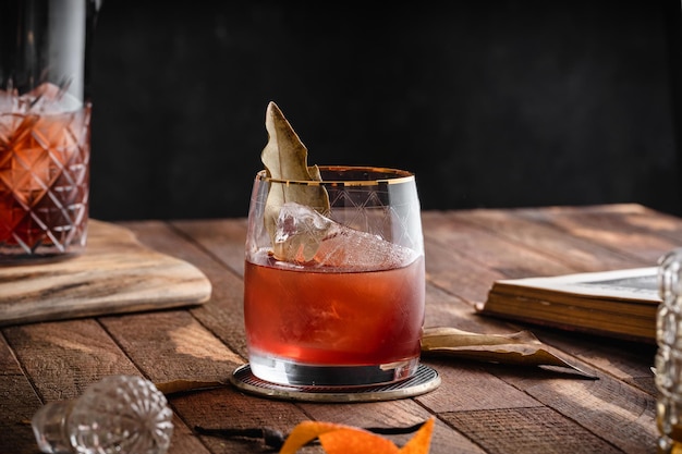 Vista de um coquetel marrom em um copo colocado sobre uma superfície de madeira com outras bebidas