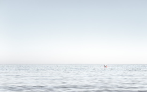 Vista de um homem andando de caiaque nas águas calmas do mar