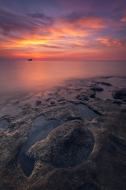 Vista deslumbrante da paisagem marítima e das rochas no dramático pôr do sol