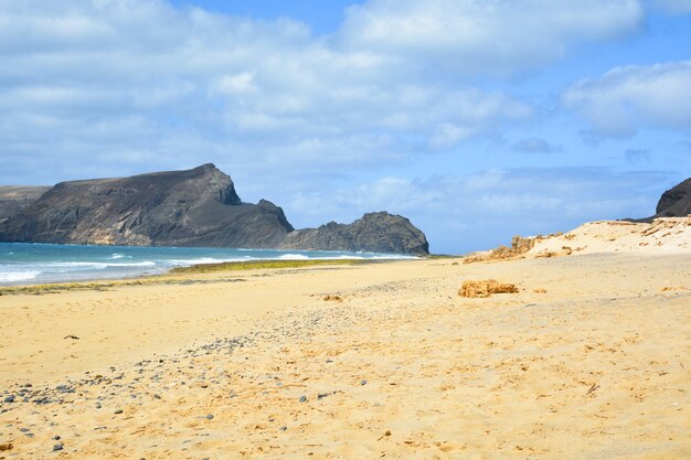 Vista deslumbrante da praia de Porto Santo com uma enorme formação rochosa