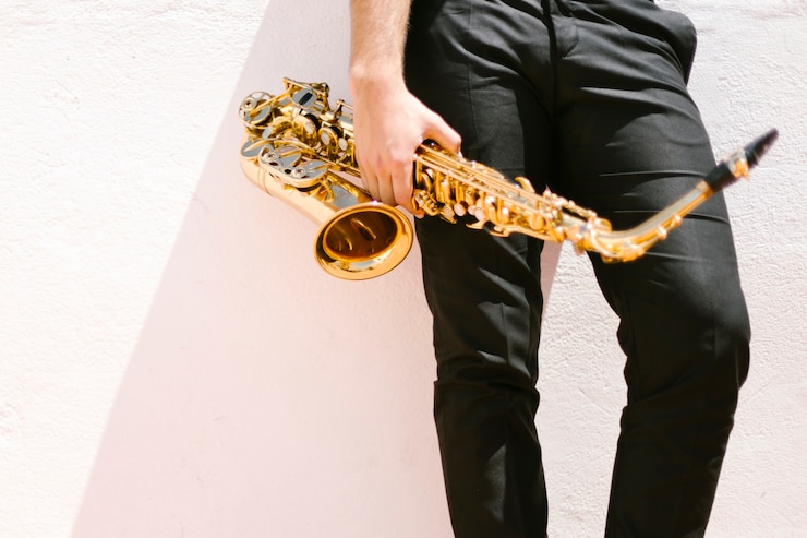 Foto grátis vista dianteira, de, homem, segurando, saxofone