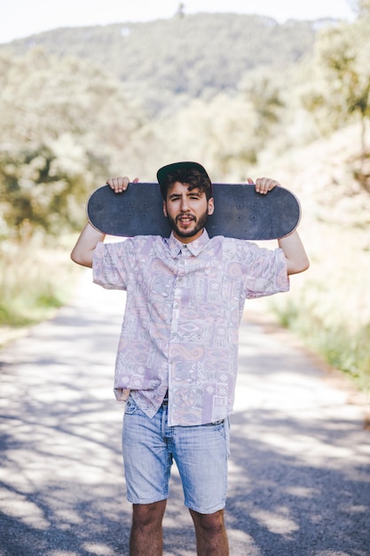 Vista dianteira, de, homem, segurando, skateboard