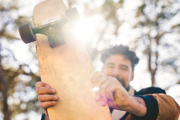 Vista dianteira, de, homem, segurando, skateboard