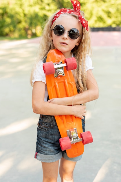 Foto grátis vista dianteira, de, menina, segurando, skateboard