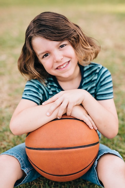 Foto grátis vista dianteira, de, menino, segurando basquetebol