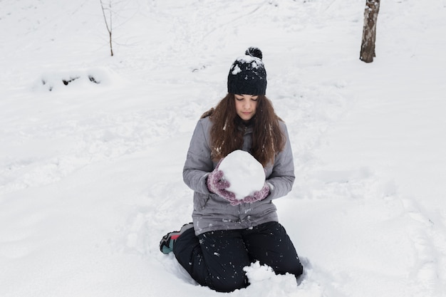 Vista dianteira, de, um, menina, segurando, snowball, em, paisagem inverno