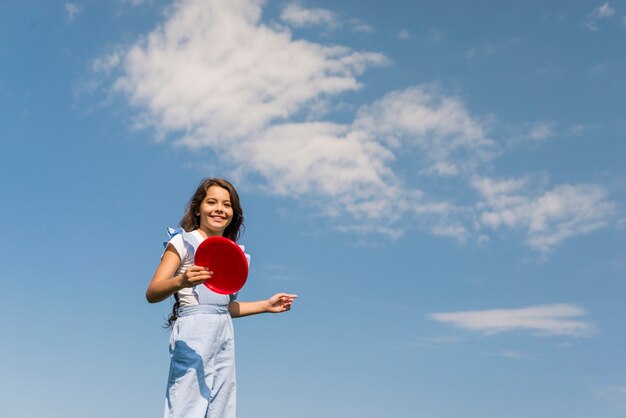 Vista dianteira, menininha, tocando, com, vermelho, frisbee