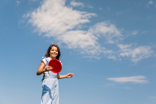 Vista dianteira, menininha, tocando, com, vermelho, frisbee