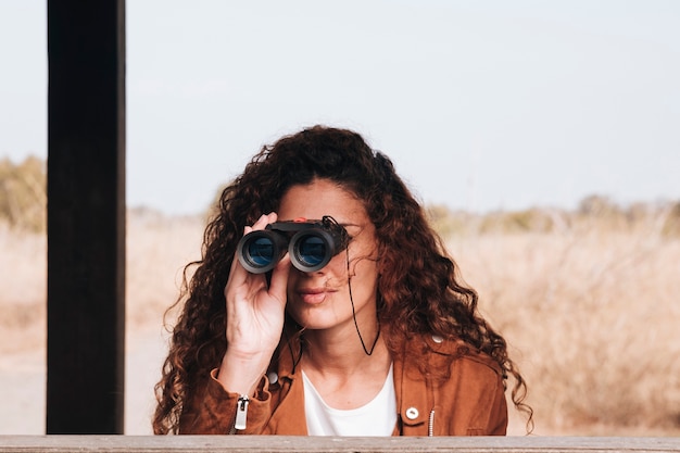 Foto grátis vista dianteira, mulher olha, através, binóculos