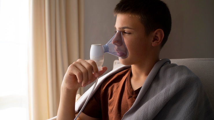 Foto grátis vista do adolescente usando nebulizador em casa para problemas de saúde respiratória
