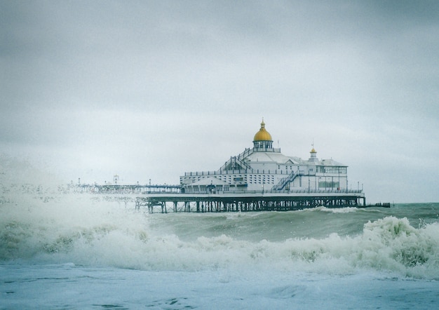 Vista do cais de Eastbourne, na Inglaterra, com ondas fortes no oceano