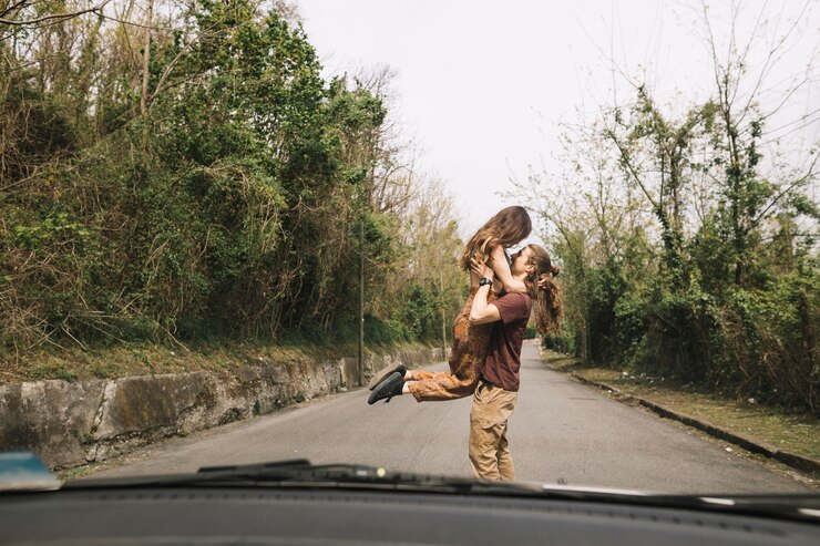 Foto grátis vista do carro do jovem casal no meio da estrada