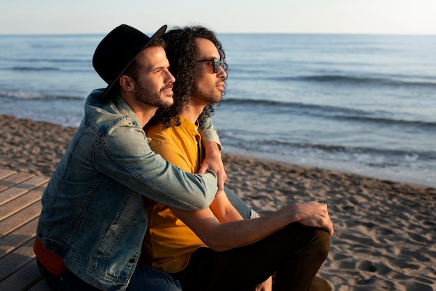 Vista do casal gay sendo carinhoso e passando tempo juntos na praia