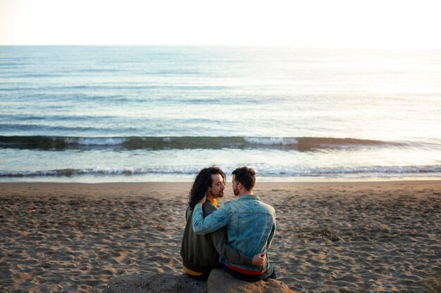 Vista do casal gay sendo carinhoso e passando tempo juntos na praia