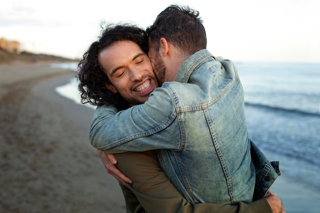 Vista do casal gay sendo carinhoso e passando tempo juntos na praia