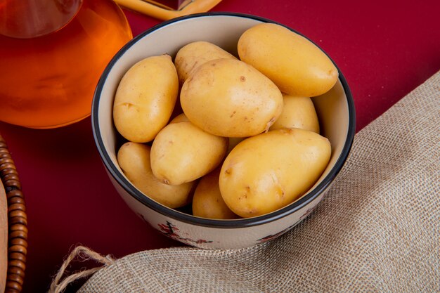 Vista do close-up de batatas novas em uma tigela com saco e manteiga derretida