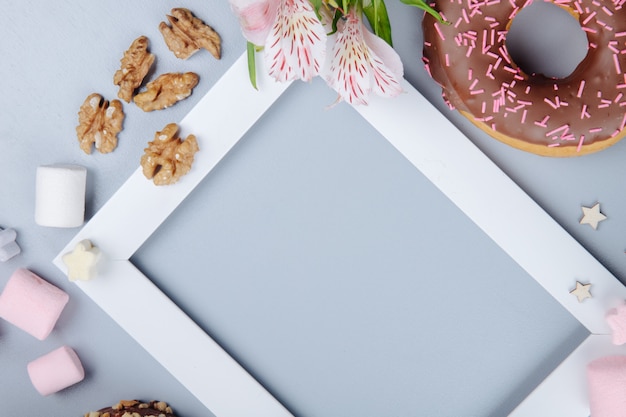 Vista do close-up de doces com biscoitos de nozes e flores em roxo com espaço de cópia