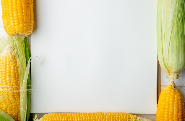 Vista do close-up de espigas de milho e bloco de notas com espaço de cópia