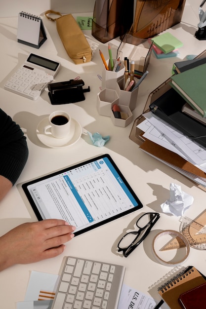 Foto grátis vista do espaço de trabalho de escritório bagunçado com dispositivo tablet