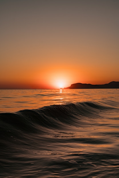 Foto grátis vista do mar com céu claro e ondas ao pôr do sol