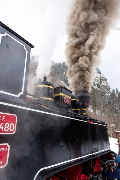 Vista do trem a vapor Mocanita em uma estação ferroviária na neve do inverno Romênia