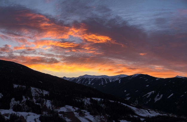 Vista fascinante das montanhas cobertas de neve durante o nascer do sol