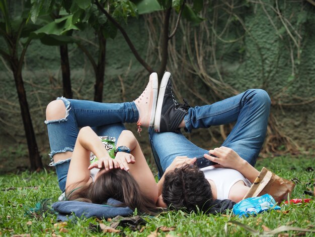 Vista fascinante de um lindo casal deitado na grama na floresta