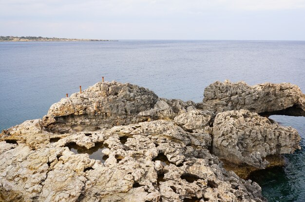 Vista fascinante do penhasco na costa de um oceano sob o céu azul