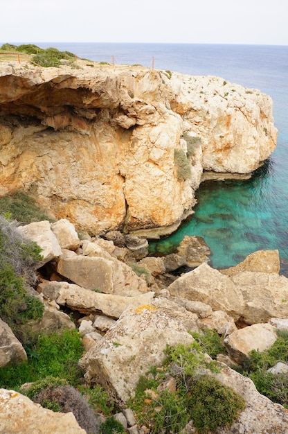 Vista fascinante do penhasco perto do oceano límpido sob o céu azul