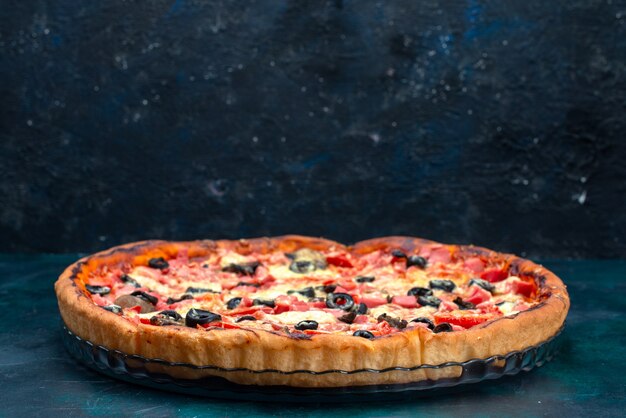 Vista frontal assada deliciosa pizza com salsichas de azeitonas e queijo na mesa azul.