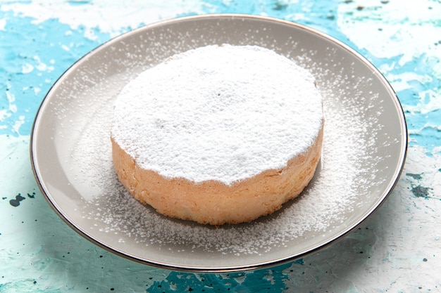 Vista frontal bolo redondo com açúcar em pó dentro do prato na superfície azul claro bolo assar biscoito açúcar doce cor de chá