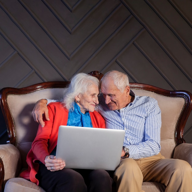 Foto grátis vista frontal casal sênior segurando um laptop