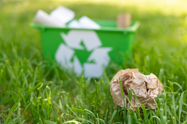 Vista frontal, cesta de reciclagem na grama com lixo