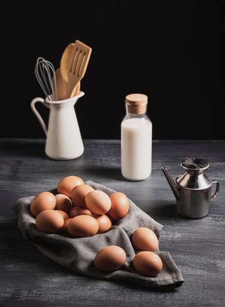 Vista frontal coleção de utensílios de cozinha ao lado de ovos