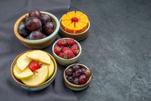 Vista frontal composição de frutas diferentes frescas e maduras em fundo cinza escuro frutas maduras saúde cor suave