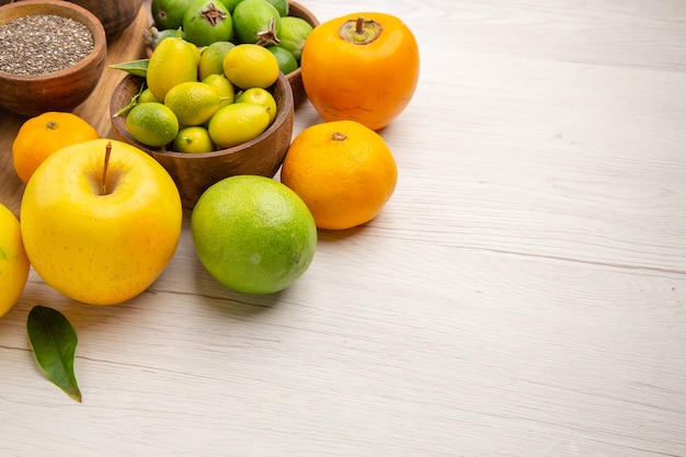 Vista frontal composição de frutas frescas frutas diferentes em fundo branco saúde frutas cítricas cor madura saborosa dieta exótica