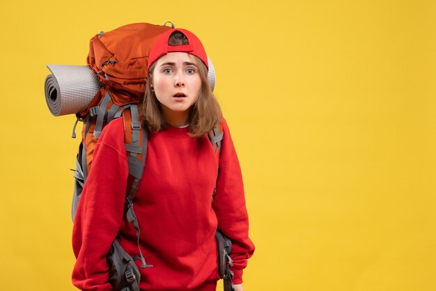 Vista frontal confusa viajante feminina com mochila olhando para frente