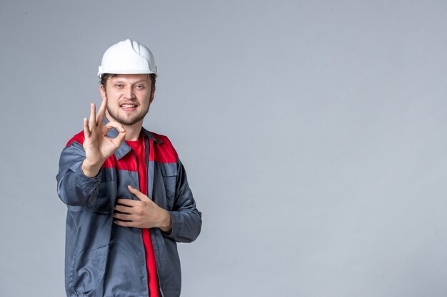 vista frontal, construtor masculino de uniforme com rosto encantado em fundo claro