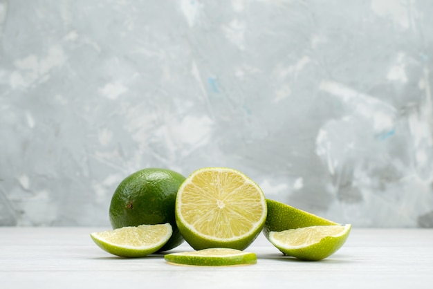 Vista frontal cortada frutas suculentas e azedas de limão fresco em branco