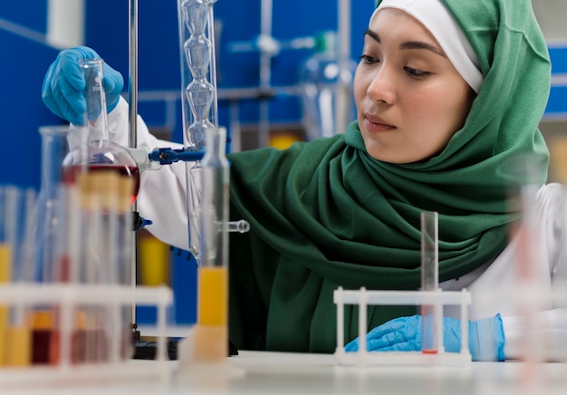 Vista frontal da cientista feminina com hijab em laboratório