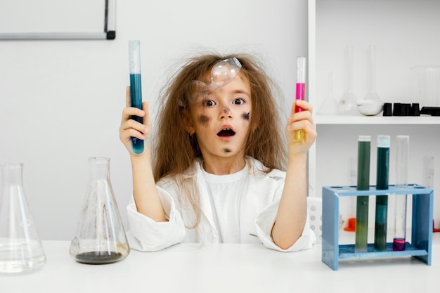 Vista frontal da cientista no laboratório com tubos de ensaio e experimento falhado