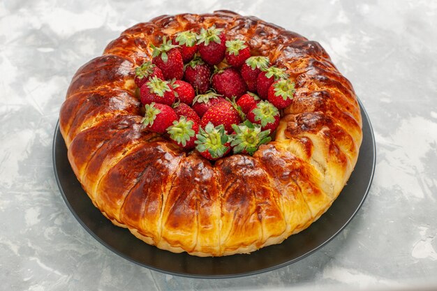 Vista frontal da deliciosa torta de morango com morangos vermelhos frescos na mesa branca