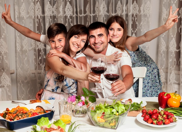 Foto grátis vista frontal da família sorridente na mesa de jantar